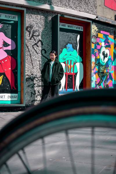 Girl walks down street with graffiti in London